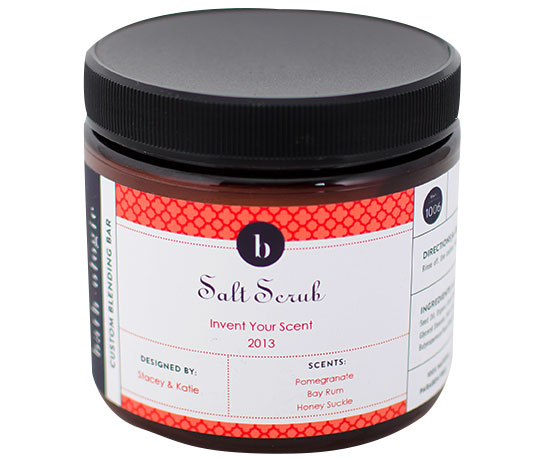 A black tub of our Signature Sea Salt Scrub with a coral label, over a white background.